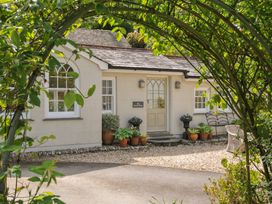 A house with potted plants and a sign at The Coach House at Pendower House Fowey