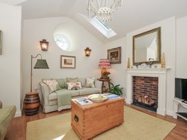 A living room with a sofa and coffee table at The Coach House at Pendower House in Fowey