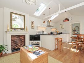 A kitchen with a fireplace and kitchen island at The Coach House at Pendower House in Fowey