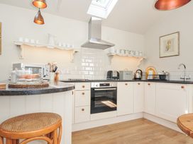 A kitchen equipped with appliances and shelving at The Coach House at Pendower House Fowey