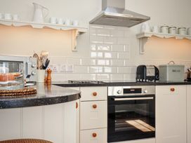A kitchen with an oven and microwave at The Coach House at Pendower House Fowey