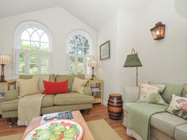 A living room with a green sofa and coffee table at The Coach House at Pendower House Fowey