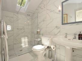 A bathroom with a shower, toilet, and sink at The Coach House at Pendower House in Fowey