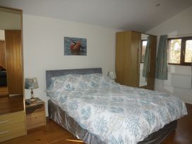 A bedroom with a bed and wardrobe at Dilly Dally Barn Bradworthy near Bude