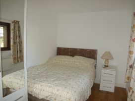A bedroom with a bed and bedside table at Dilly Dally Barn near Bradworthy