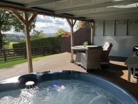 An outdoor area with a hot tub and seating at Shepherds Cabin at Titterstone Clee Hill
