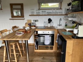 A kitchen with wooden furniture and appliances at Shepherds Cabin at Titterstone Clee Hill
