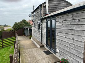 A wooden building with decking and garden area at Shepherds Cabin at Titterstone Clee Hill
