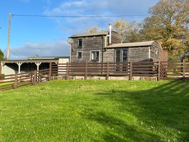 A cabin with a fence and grass at Shepherds Cabin at Titterstone in Clee Hill