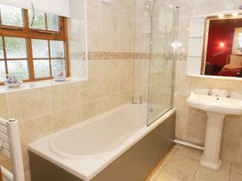 A bathroom with a bathtub and shower next to a pedestal sink at Gelli Glud in Eglwysbach