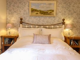 A bedroom with a bed and bedside tables at Gelli Glud in Eglwysbach