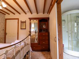 A bedroom with a bed and wardrobe at Gelli Glud Eglwysbach