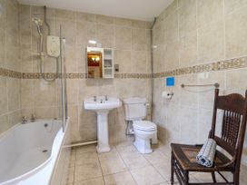 A bathroom with a bathtub, shower, sink, and toilet at Gelli Glud in Eglwysbach