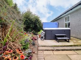 A garden with a hot tub and flowers at Gelli Glud in Eglwysbach