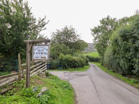An entrance sign to Gelli Glud self catering with a road in Eglwysbach