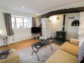 A living room with a sofa, coffee table, and television at Happy Landing in Llanfair