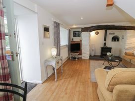 A living room with a fireplace and a sofa at Happy Landing in Llanfair
