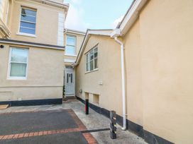 An exterior view of a beige building with windows and a door at Cottage 1 Newcourt in Torquay