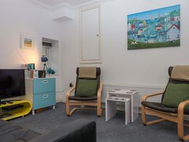 A living room with a television and armchairs at Cottage 1 Newcourt Torquay
