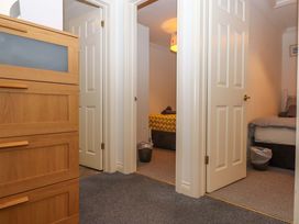 A bedroom with a dresser and two doors at Cottage 1 Newcourt in Torquay