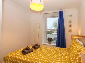 A bedroom with a bed and a window at Cottage 1 Newcourt in Torquay
