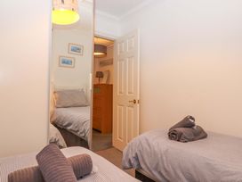 A bedroom with two beds and a dresser at Cottage 1 Newcourt in Torquay
