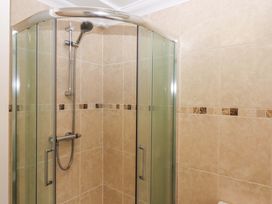 A shower area with glass door and tiled walls at Cottage 1 Newcourt Torquay