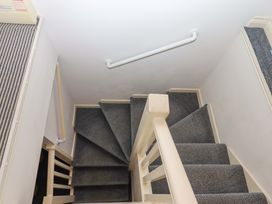 A staircase with carpet and a handrail at Cottage 1 Newcourt in Torquay