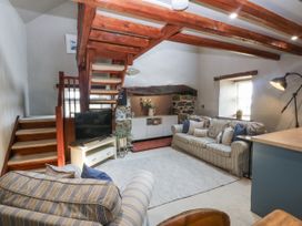 A living room with a staircase and television at Cegin Foch in Chwilog