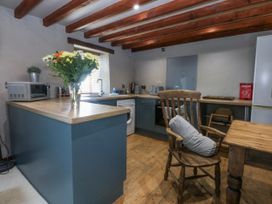 A kitchen with appliances and furniture at Cegin Foch in Chwilog