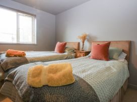 A bedroom with two beds and a nightstand at Cegin Foch in Chwilog