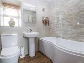 A bathroom with a toilet, sink, shower, and bathtub at Cegin Foch in Chwilog