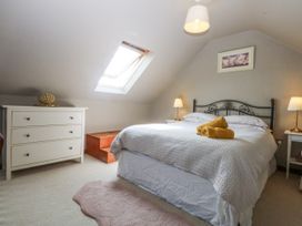 A bedroom with a bed and furniture at Cegin Foch in Chwilog