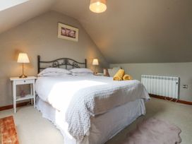 A bedroom with a bed and lamps at Cegin Foch in Chwilog