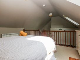 A bedroom with a bed and a towel at Cegin Foch in Chwilog