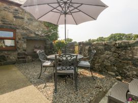 An outdoor patio with a table and chairs at Cegin Foch in Chwilog