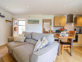 A living room with a sofa and dining area at Cawsand in Tideford