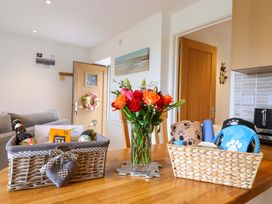 A dining room with a table containing gift baskets and flowers at Cawsand in Tideford