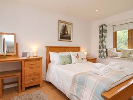 A bedroom with a bed and dresser at Cawsand in Tideford