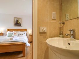 A bathroom with sink and towels next to a bedroom at Cawsand in Tideford