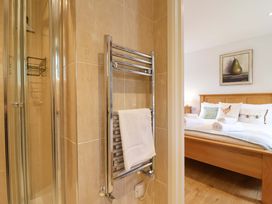 A bathroom with a shower and towel rail leading to a bedroom at Cawsand in Tideford