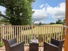 A balcony with chairs and a table overlooking a landscape at Cawsand in Tideford