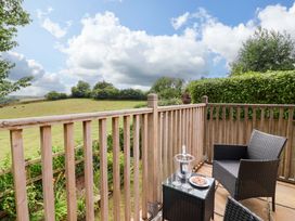 An outdoor space with a chair and table on a balcony at Cawsand in Tideford