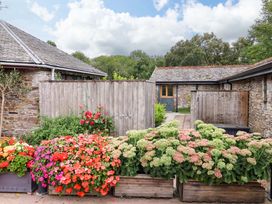 An outdoor area with flowers and a wooden fence at Cawsand in Tideford