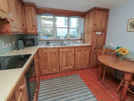 A kitchen with wooden cabinets and a table at Bramla in Staithes
