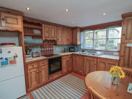 A kitchen with wooden cabinets and appliances at Bramla in Staithes