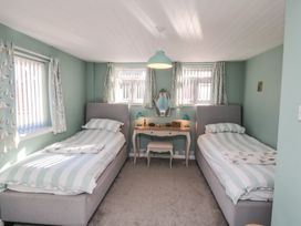 A bedroom with two single beds and a desk at Bramla in Staithes