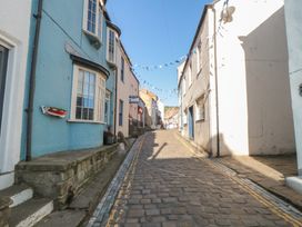 A cobblestone street with blue and white houses at Bramla in Staithes