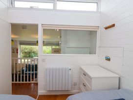 A bedroom with a window and dresser at 2 Brook Cottages Hope Cove