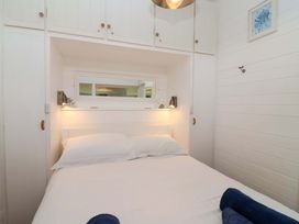 A bedroom with a bed and wardrobe at 2 Brook Cottages in Hope Cove